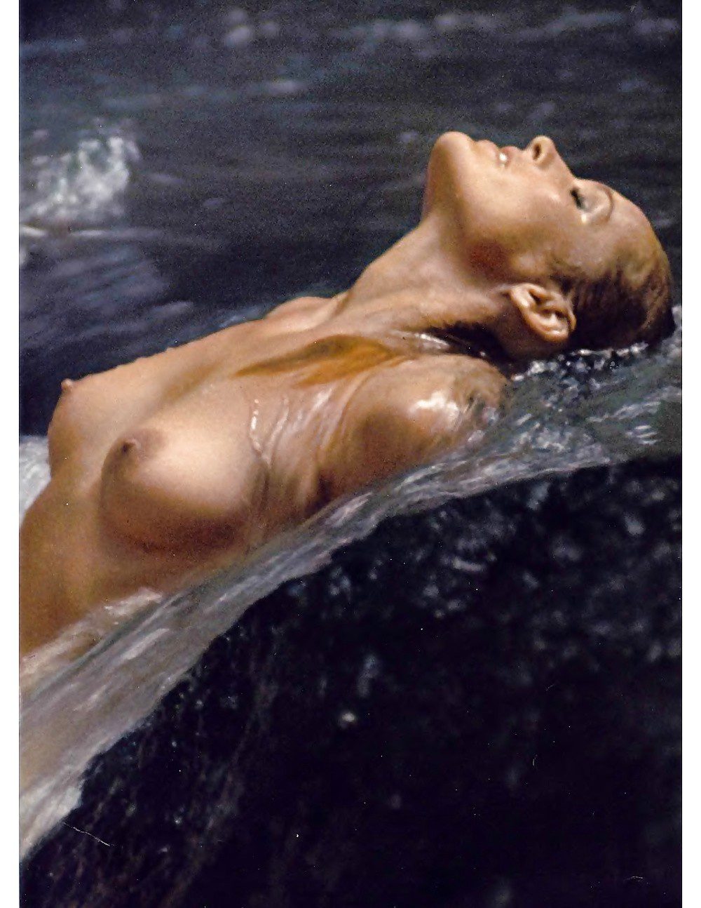 Ursula Andress letting the water run over her